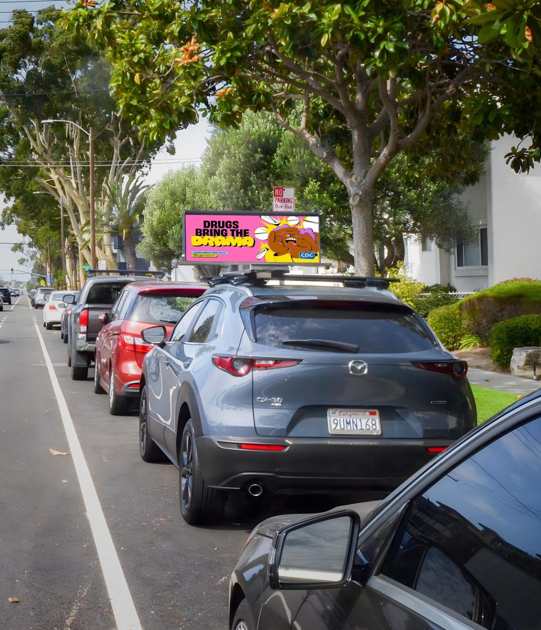 A Quantum Digital Topper running a CDC public health campaign on a residential street with a no parking sign