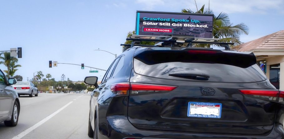 A Quantum Digital Topper on a parked vehicle running a live digital campaign at a Los Angeles intersection