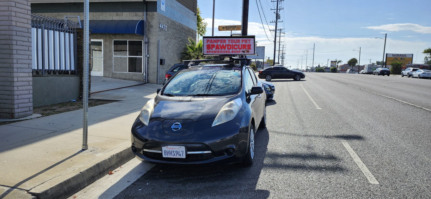 A Quantum Digital Topper on a parked car in front of a storefront running a local business advertisement